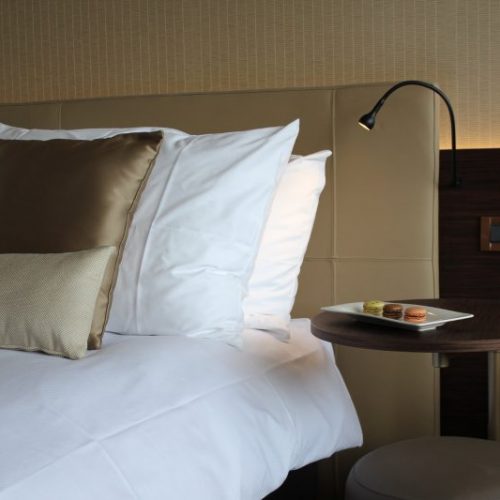 Crowne Plaza Geneva rooms bedside table and bed. - Gitaly contract