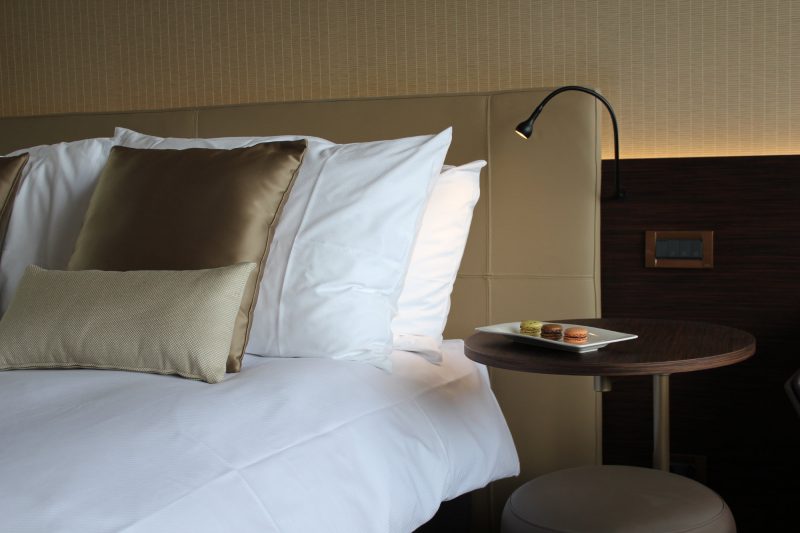 Crowne Plaza Geneva rooms bedside table and bed. - Gitaly contract